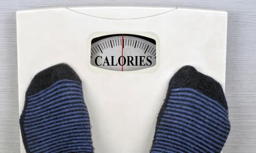 Standing on scale that says calories.