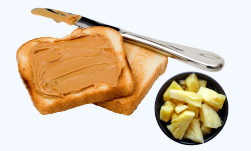Peanut butter toast with pineapple fruit cup on side.